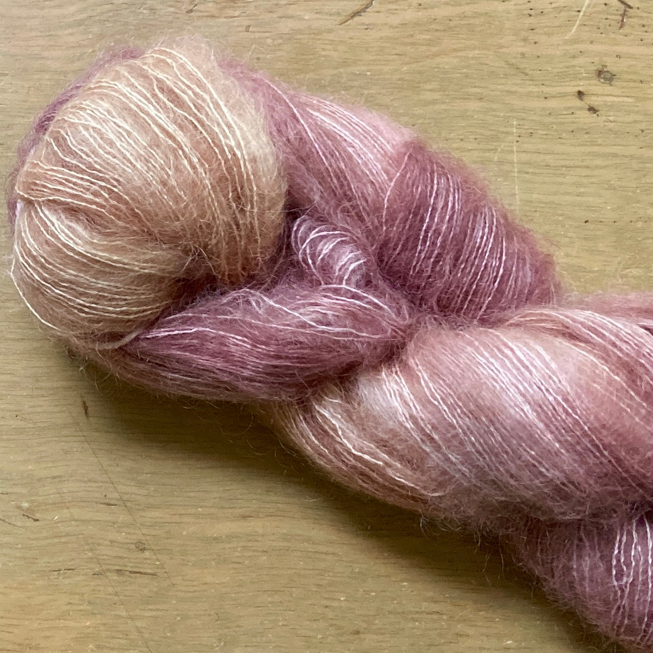 Variegated pink skein of Hand Maiden Superkid Silk yarn. 