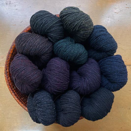 Basket of dark Harrisville nightshades yarn on a wooden surface