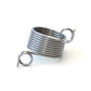 Close up on Addi knitting thimble, a silver ring with two coils for threading yarn through. 