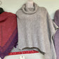 Gray knit poncho hanging on display at Hillsborough Yarn Shop. 