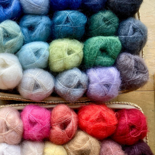 colorful skeins of Isager Silk Mohair yarn stacked on a shelf - for sale at Hillsborough Yarn Shop, NC, USA