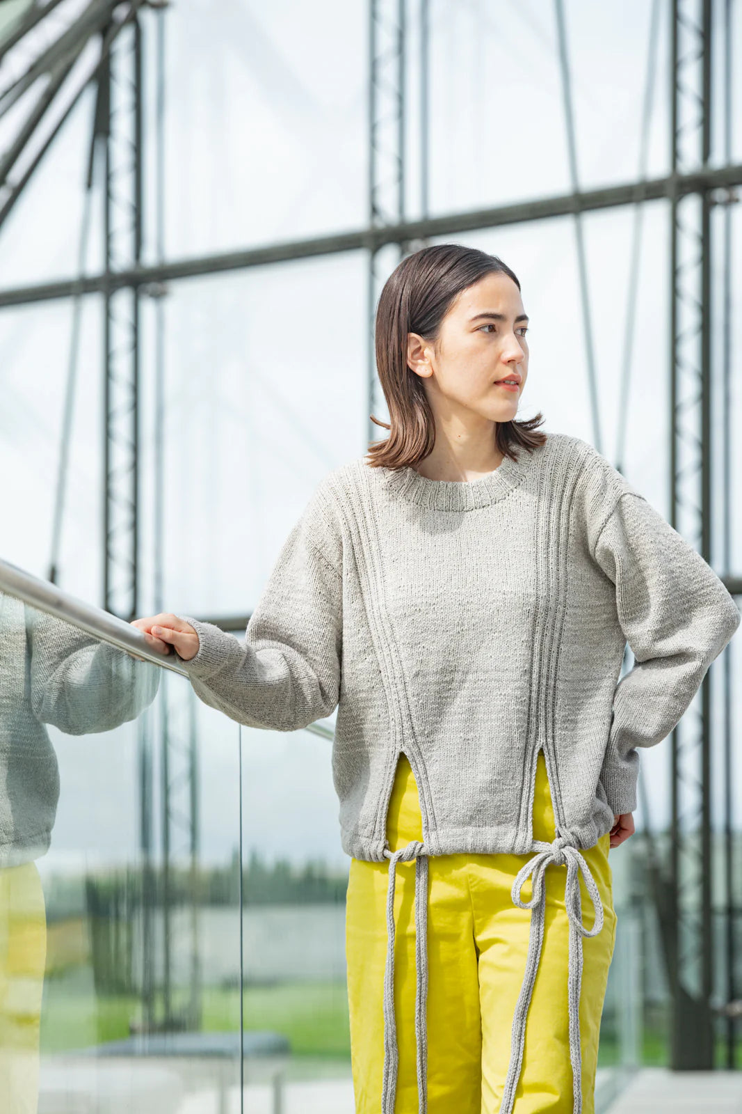 Person wearing gray handknit sweater, showing off a pattern from Brooklyn Tweed’s Northern Lights book. 