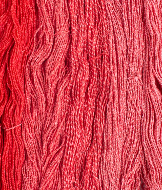 Skeins of bright red Brooklyn Tweed Dapple yarn. 