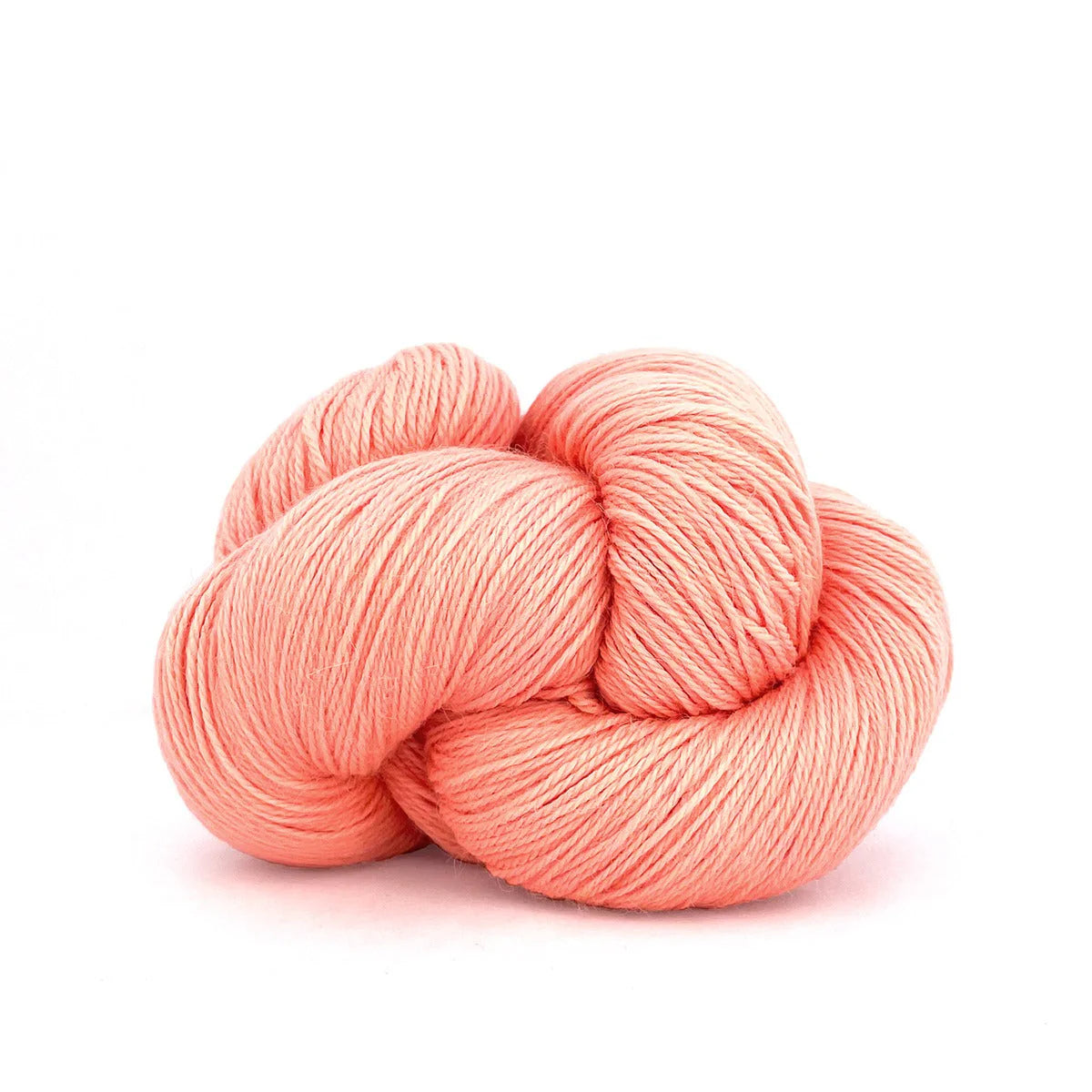 Close-up of a skein of pastel orange Perennial yarn by Kelbourne Woolens in color Cantaloupe.