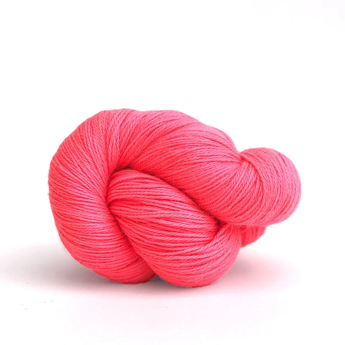 Close-up of a skein of neon coral Perennial yarn by Kelbourne Woolens.