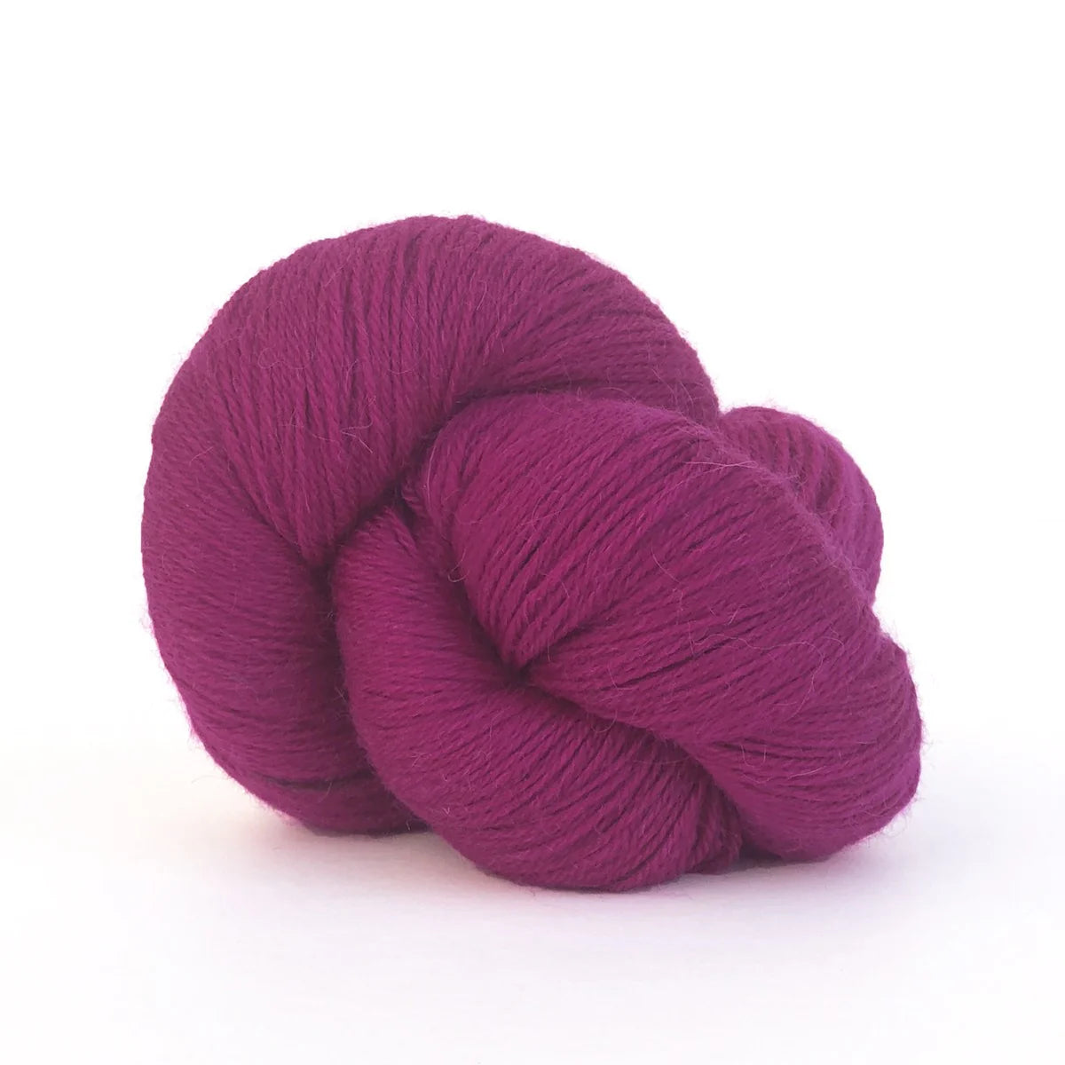 Close-up of a skein of deep pink Perennial yarn by Kelbourne Woolens in color Raspberry.