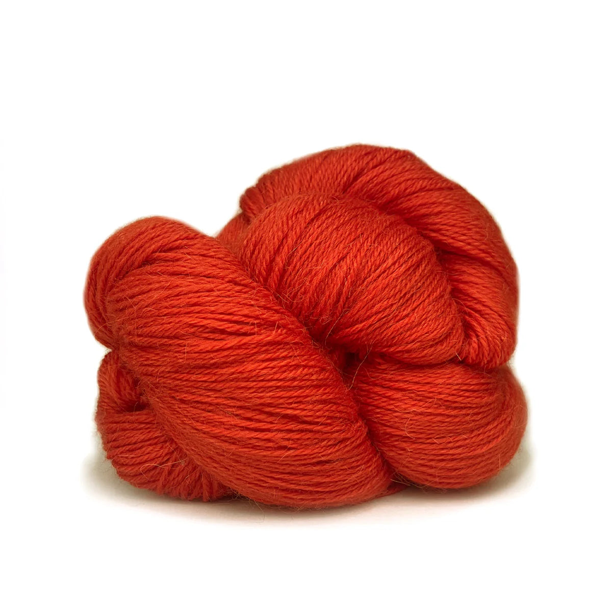 Close-up of a skein of bright orange-red Perennial yarn by Kelbourne Woolens in color Vermillion.