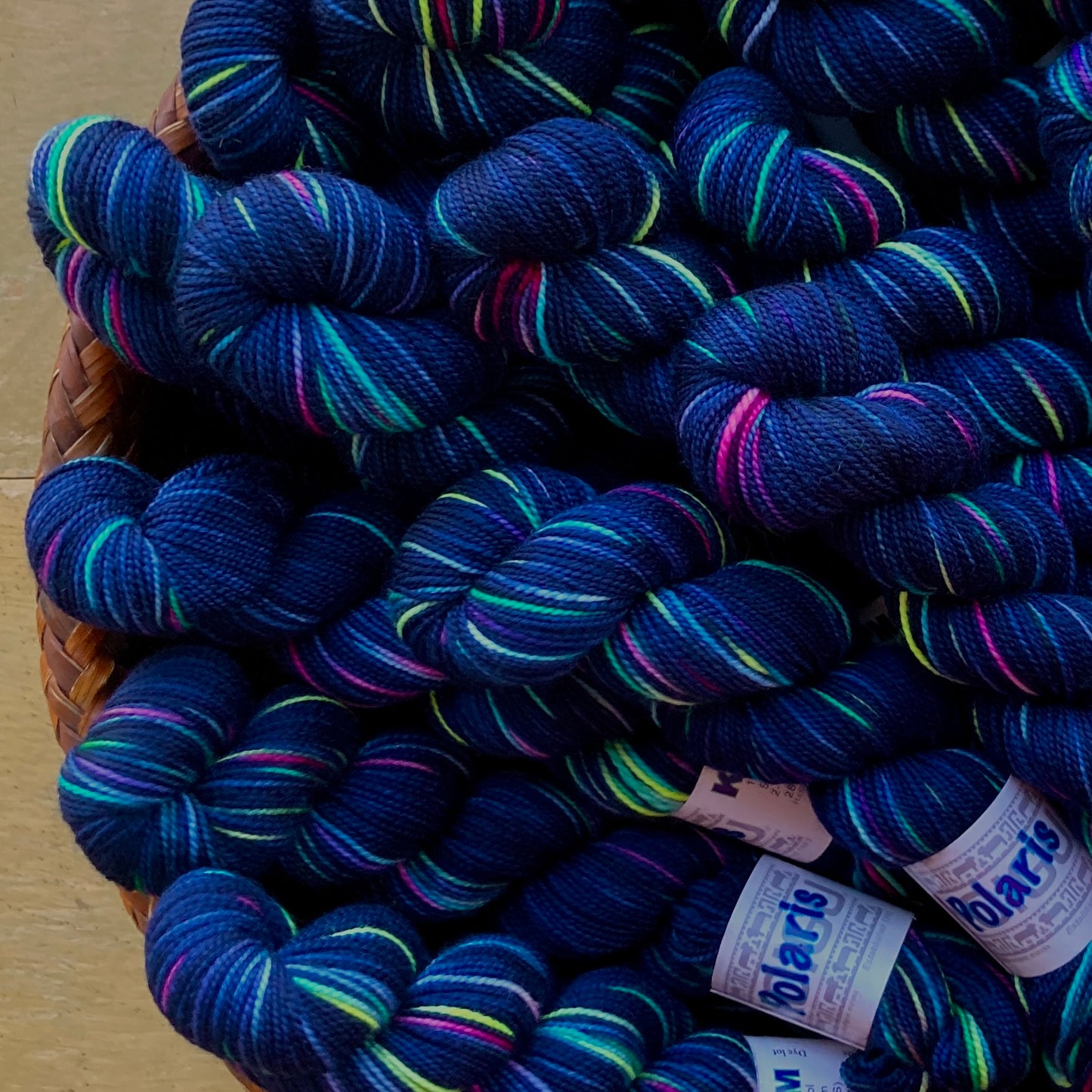 Variegated blue skeins of Koigu KPPPM with neon streaks, colorway Polaris