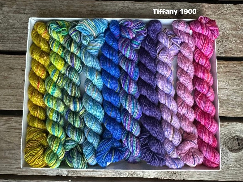 Rectangular package holding ten mini skeins of colorful hand dyed Koigu KPPPM yarn. 