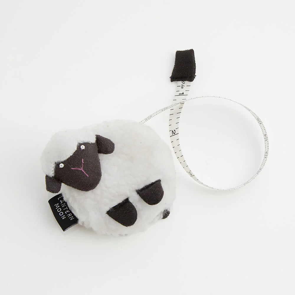 White sheep-shaped tape measure. 