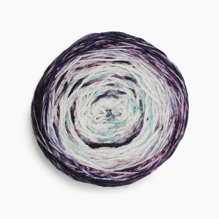 Ball of gradient Malabrigo Metamorphosis Sock yarn in shades of purple and white. 