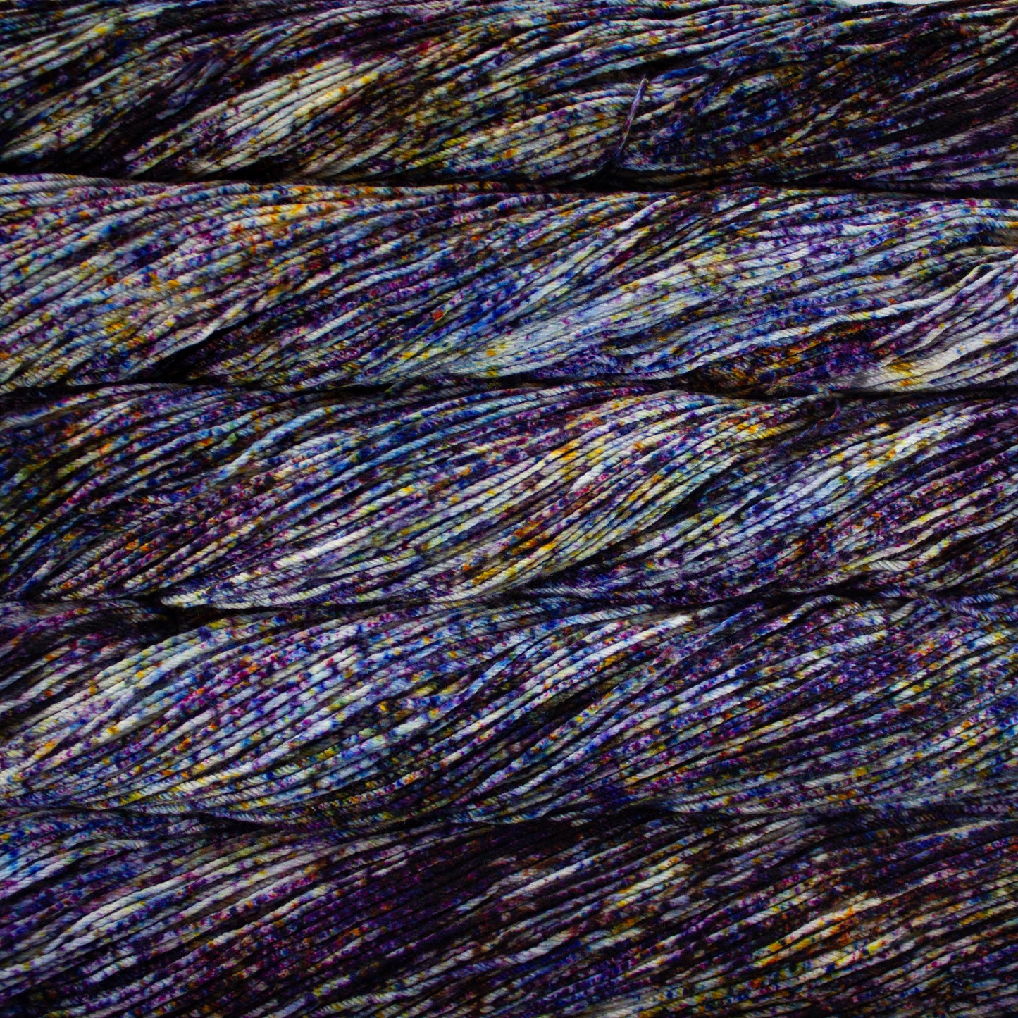 Skein of speckled blue, purple, and white Malabrigo Arroyo yarn. 