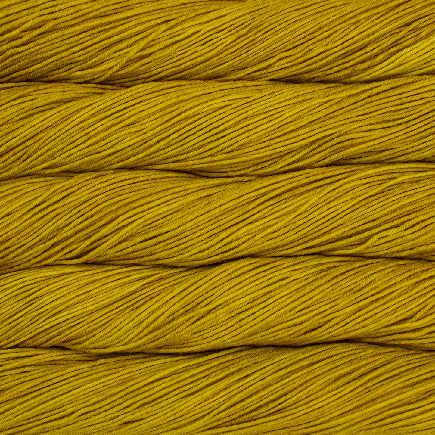 Skein of semisolid mustard yellow Malabrigo Arroyo yarn. 