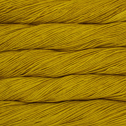 Skein of semisolid mustard yellow Malabrigo Arroyo yarn. 