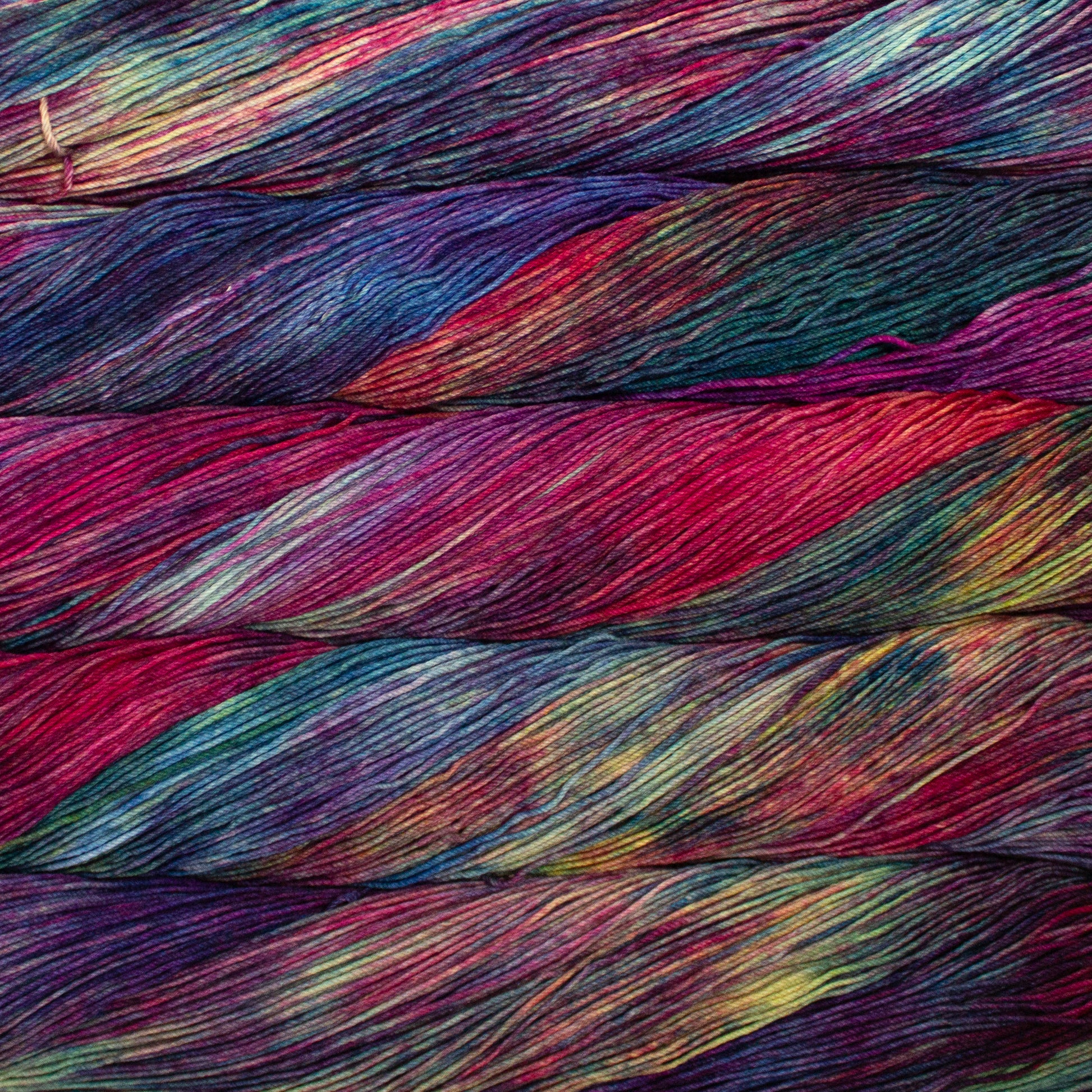 Variegated skeins of red, yellow, and blue yarn - Ultimate Sock by Malabrigo in color Aniversario