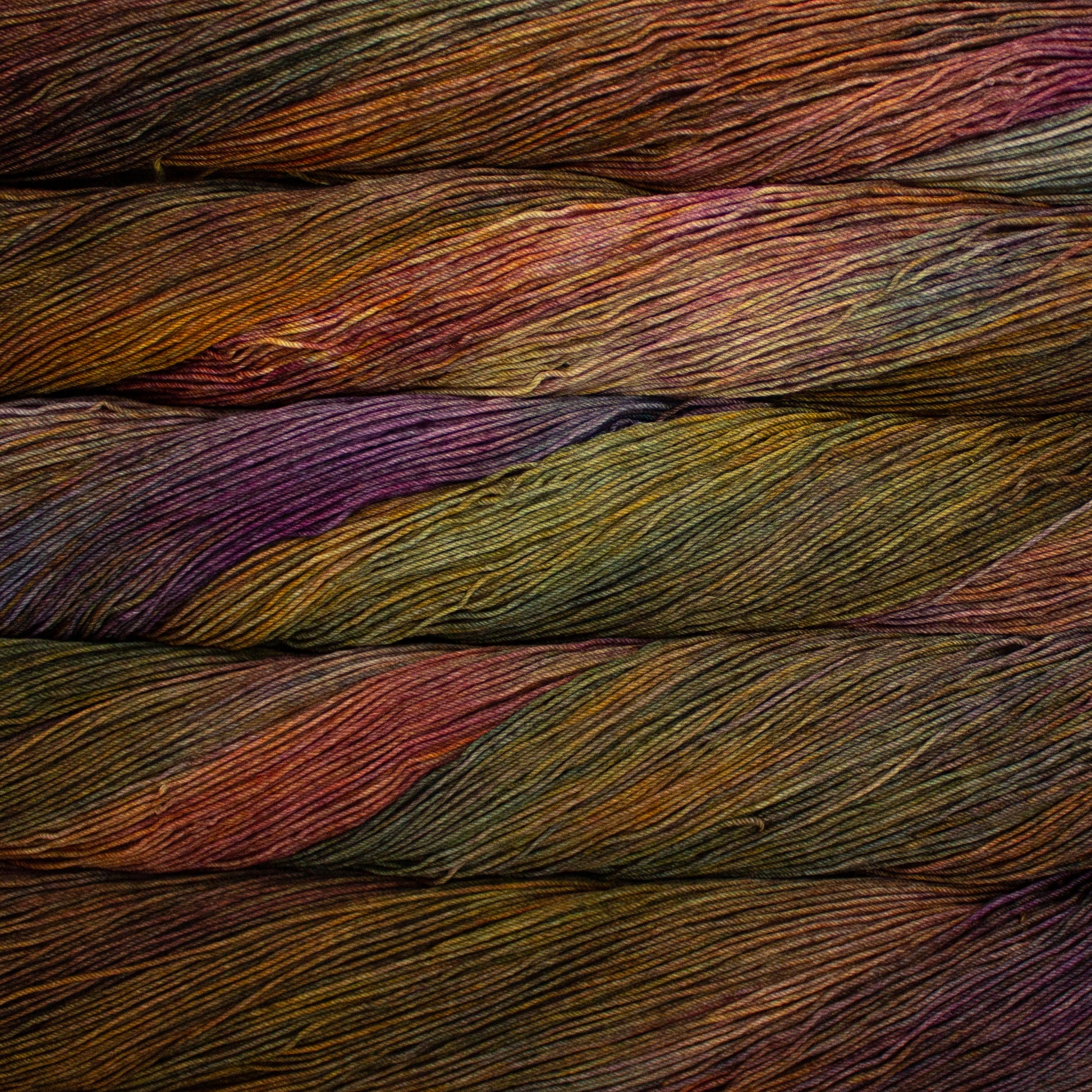 Variegated skeins of soft orange, mossy green and purple yarn - Ultimate Sock by Malabrigo