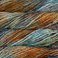 Close up on rust and blue variegated skein of Malabrigo Rasta yarn in color Amphibian. 