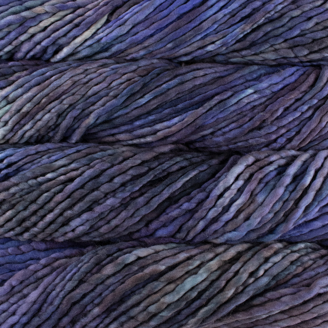 Close up on purple gray variegated skein of Malabrigo Rasta yarn in color Navagante