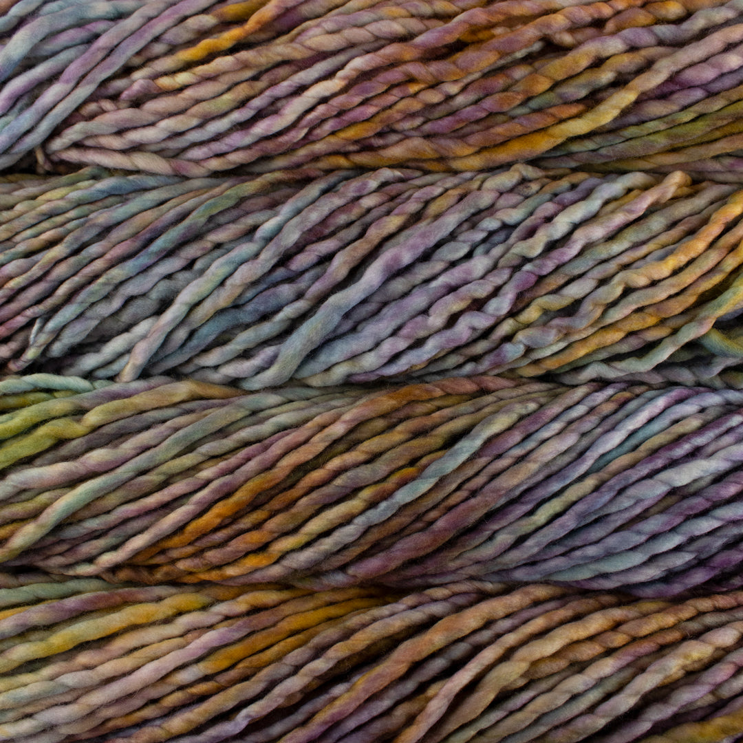 Close up on rust and lavender variegated skein of Malabrigo Rasta yarn in color dancing leaves. 