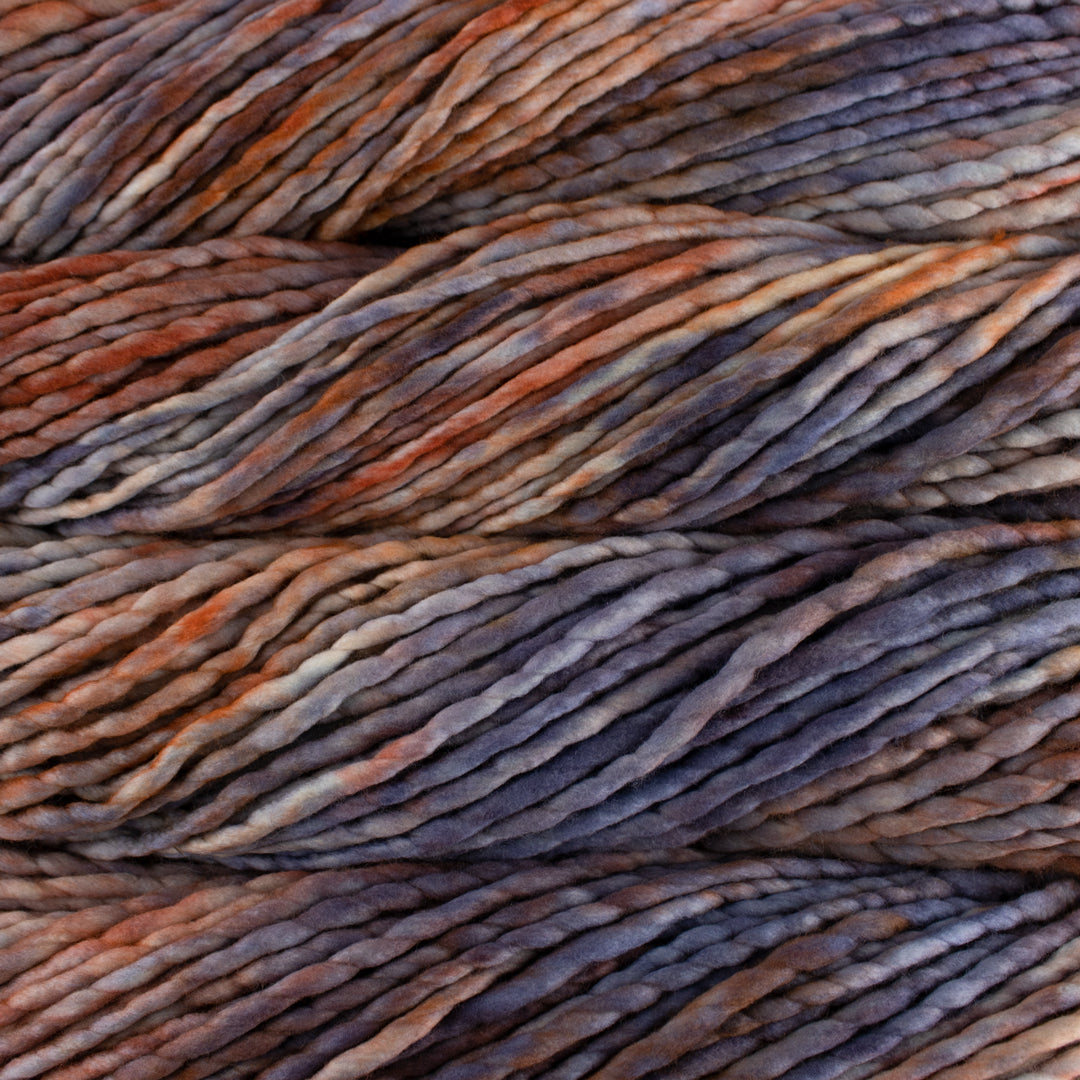 Close up on burnt orange lavender gray skein of Malabrigo Rasta yarn in color Plumage. 