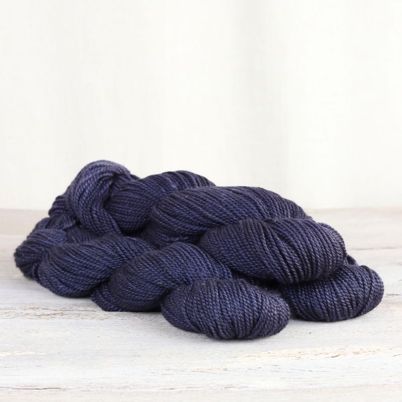 3 skeins of dark purple Fibre Co. Acadia yarn. 