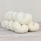 3 skeins of natural white Fibre Co. Amble yarn. 