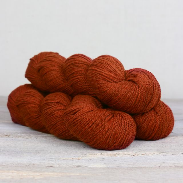 3 skeins of dark orange Fibre Co. Amble yarn. 