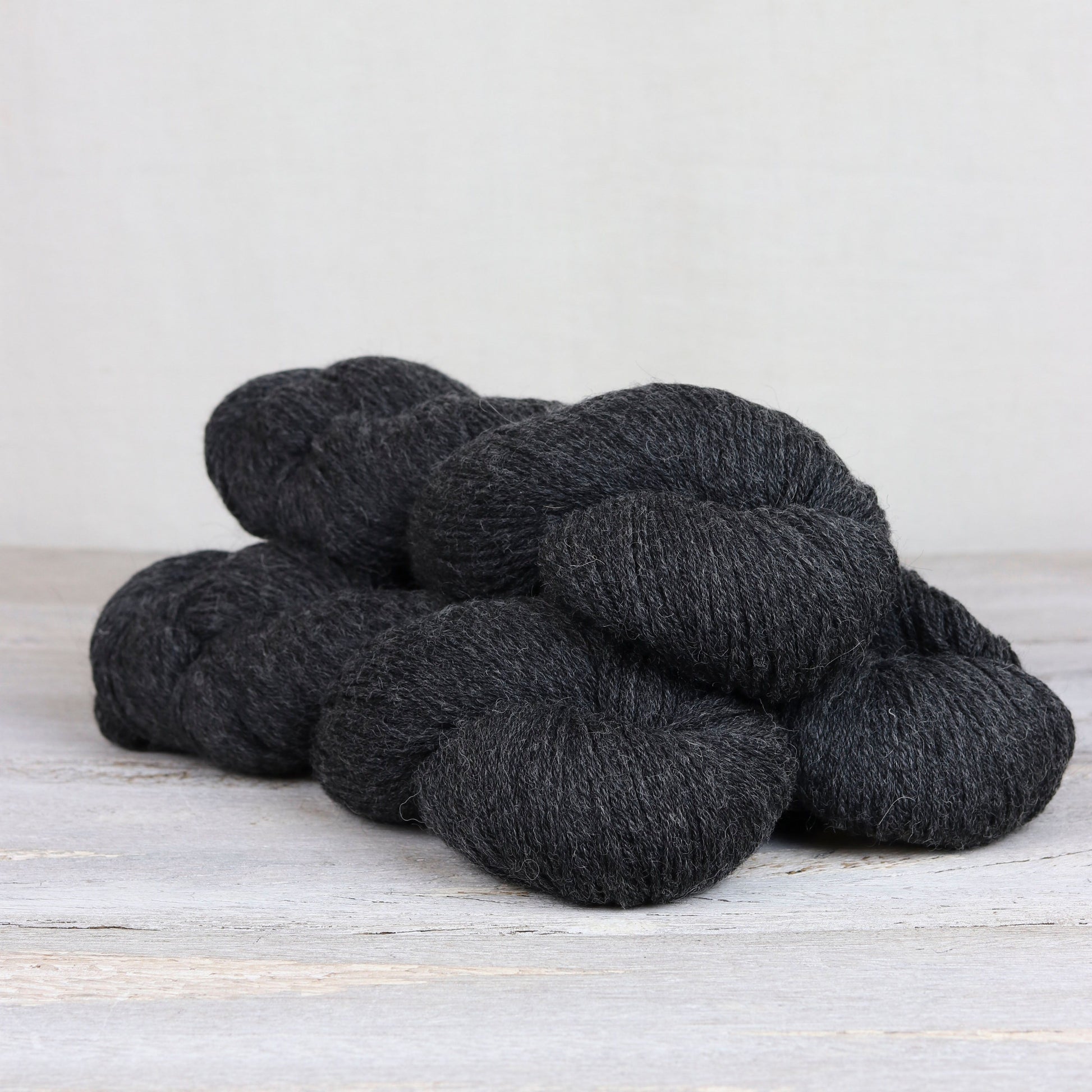 3 skeins of heathered black Fibre Co. Cumbria Fingering yarn. 