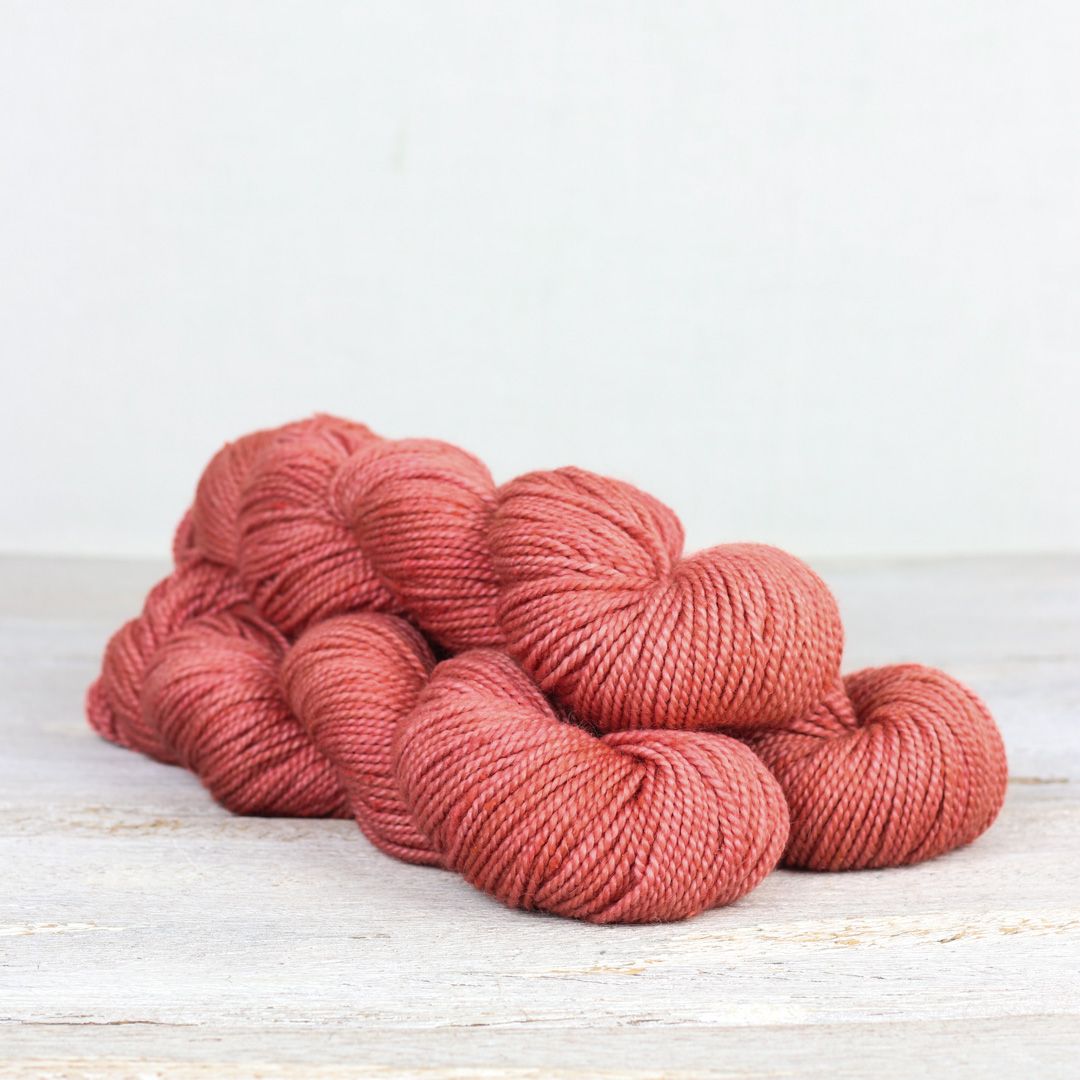 3 skeins of coral pink Fibre Co. Acadia yarn. 