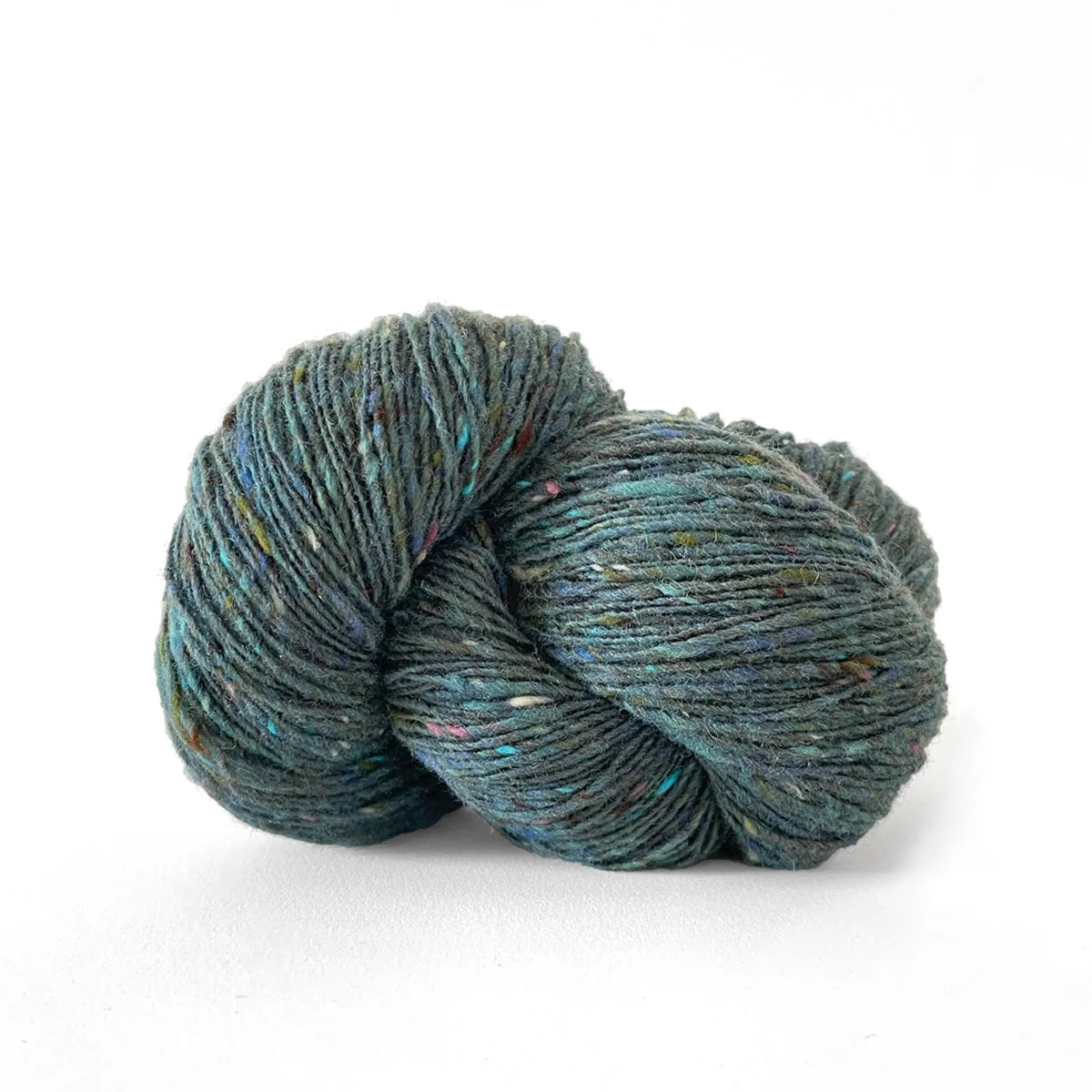 Skein of medium blue green tweed Kelbourne Woolens Cricket yarn. 