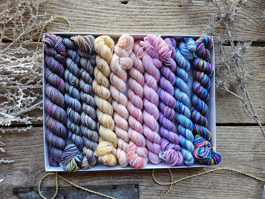 Rectangular package holding ten mini skeins of colorful hand dyed yarn. 