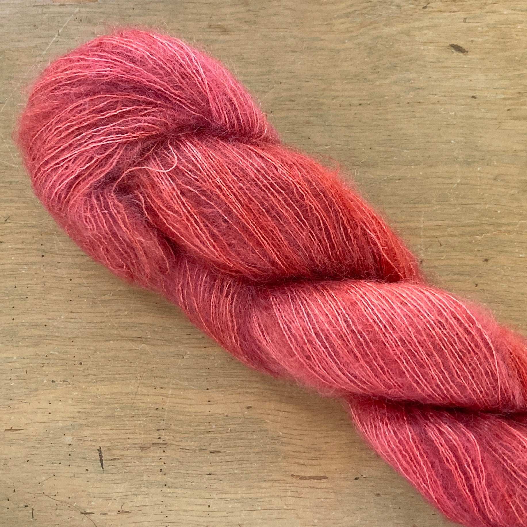 Coral skein of Fleece Artist / Hand Maiden Superkid Silk yarn. 