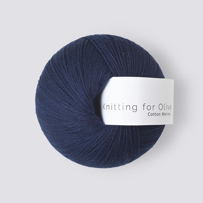 Navy blue ball of yarn with a label on a light gray background