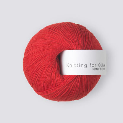 Red skein of yarn with a label on a light gray background
