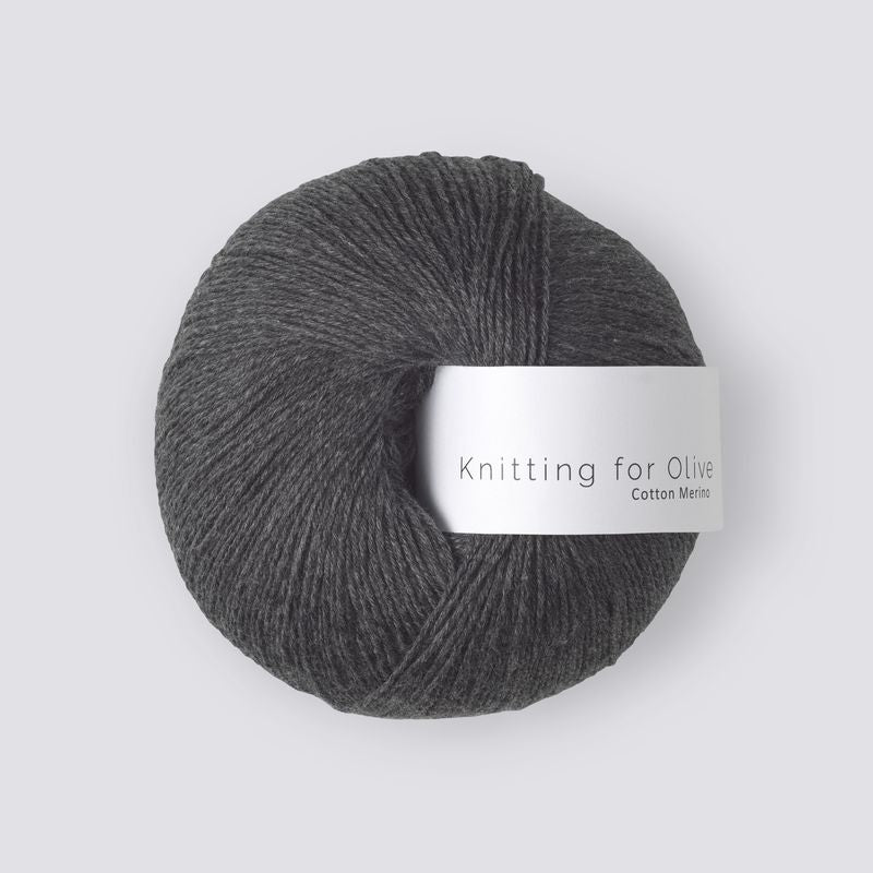 Ball of dark gray yarn with a label on a white background