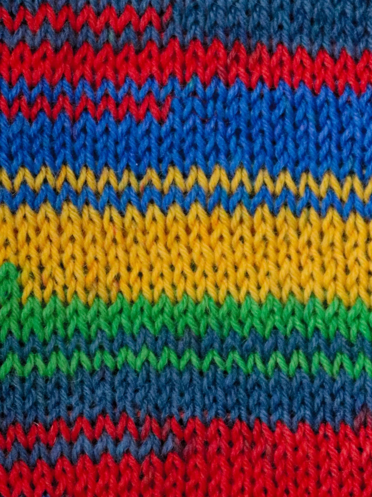 Close-up of colorful knitted fabric with red, blue, yellow, and green stripes.