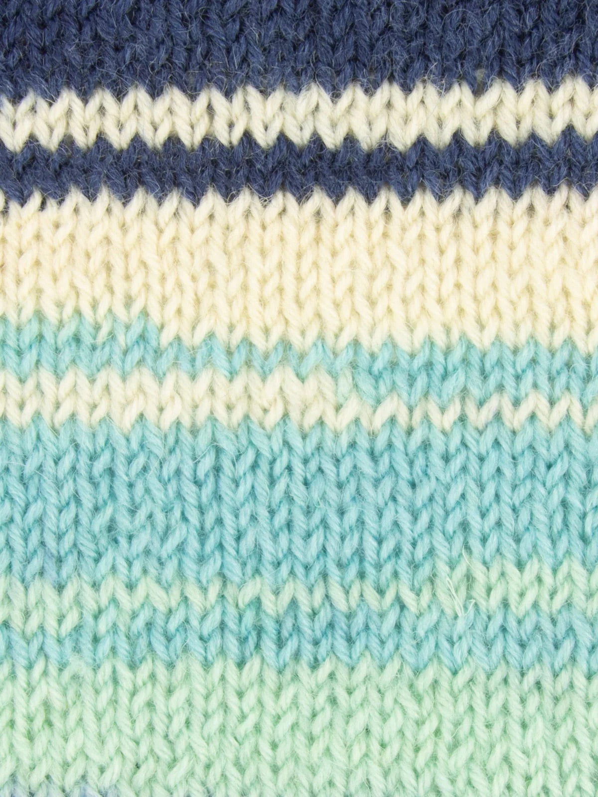 Close-up of knitted fabric with blue, white, and teal stripes that have a gradient effect.