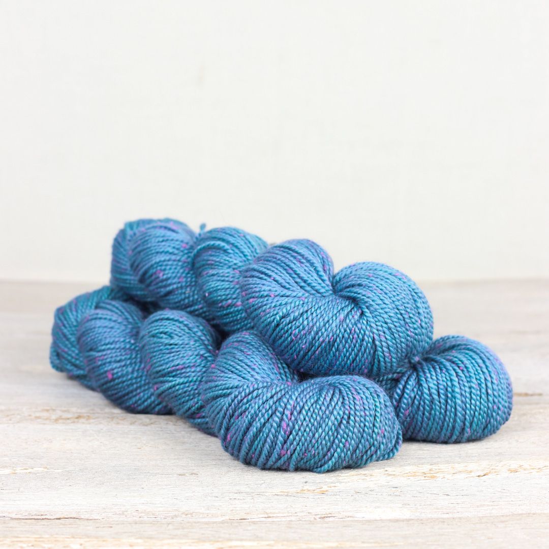 3 skeins of bright blue Fibre Co. Acadia yarn. 