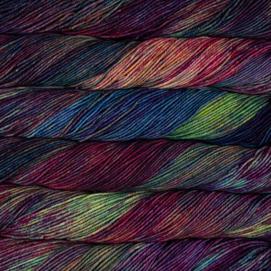 Variegated skeins of Malabrigo Seis Cabos yarn in shades of purple, blue, green, and burgundy. 